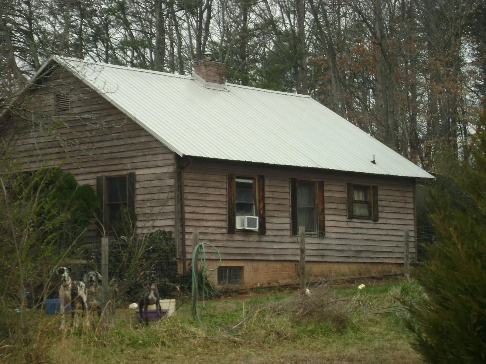 White metal roof on an old wood sided farmhouse, from a Metal Roof Installation job in North Palm Beach